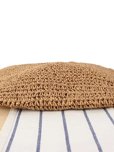 Handwoven khaki straw bag showing detailed spiral weaving craftsmanship on base