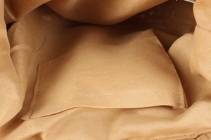 Macro detail showing the inner fabric lining and internal pocket of the woven handbag