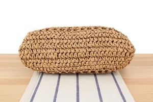 Detailed close-up showing the intricate woven texture and natural straw pattern of the bag