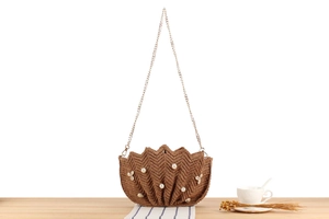 Detail of raffia woven bag showing shell shape texture with pearls and seashells