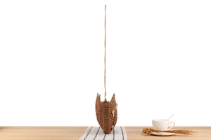 Detail of raffia woven shoulder bag with pearl shell accents and gold chain strap