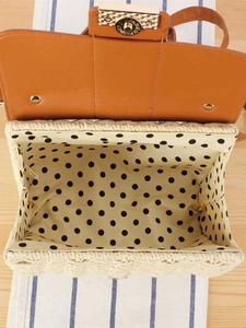 Handcrafted woven straw handbag with brown leather flap and stylish polka dot fabric lining