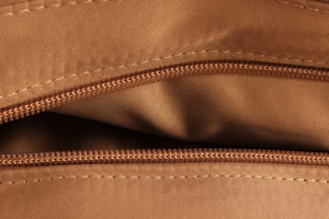 Close-up of high-quality inner lining and smooth zipper detail on a woven raffia bag