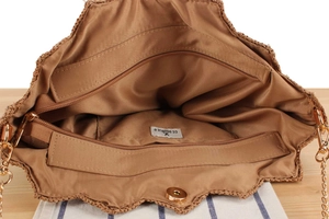 Interior view of raffia bag with polyester lining, zip pocket, and gold chain strap