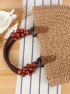 Handwoven straw bag with dark brown wood bead handles for summer beach vacation style