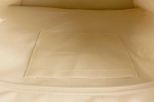 Detail view of woven bag interior featuring a sturdy slip pocket and secure zipper closure