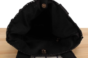 Interior view of black handwoven tote with gold magnetic clasp and zipper pocket