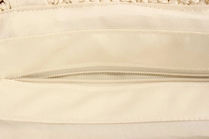 Detailed view of the woven bag interior featuring a beige lining and a secure zipper pocket