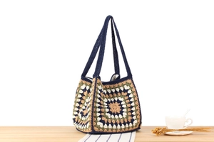 Detail of handmade crochet tote bag with colorful granny square patterns and sturdy handles