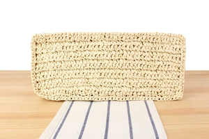 Macro detail of natural straw woven texture on a large capacity stylish beige tote bag