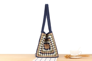 Macro shot of vintage woven tote bag with geometric pattern on a wooden table