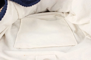Close-up of crochet bag interior featuring white cotton lining and internal patch pocket