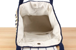 Detail of the woven tote bag interior featuring canvas lining and magnetic buckle