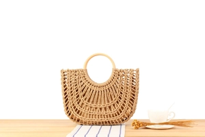 Detail of woven straw handbag with round wooden handles and soft textile lining