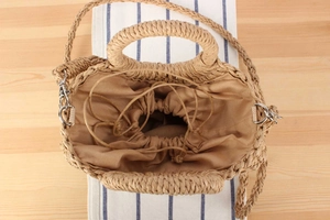 Detailed macro view of woven straw bag showing secure fabric drawstring liner and texture