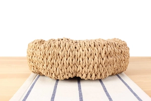 Detailed view of handmade woven bag texture and natural fiber knotting on a wooden table