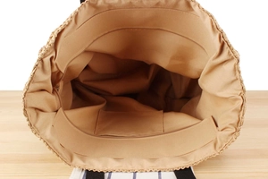 Internal view of the straw bag showing large capacity, zip pocket, and top zip closure