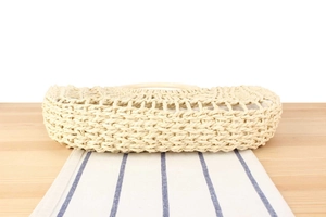 Detailed macro view of the sturdy woven bottom texture on a casual straw beach tote bag