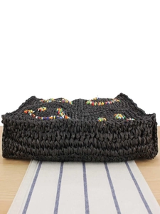 Handmade black woven straw bag with colorful floral bead patterns for beach or casual use