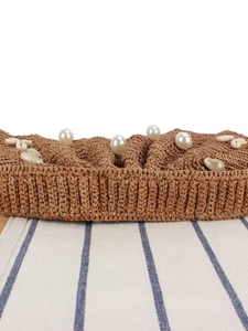 Handmade raffia woven handbag with pearl and seashell decorations for beach vacation style