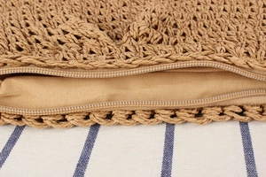 Macro shot of hand-woven straw bag texture featuring a secure zipper closure and fabric lining
