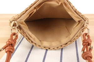 Top view detail of straw woven shoulder bag with brown leather strap and fabric lining