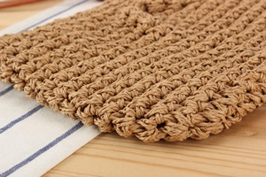 Macro detail of hand-woven straw bag texture on a minimalist wooden background