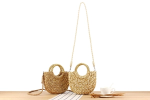 Détail de sacs demi-lune en paille faits main avec poignées rondes en marron et beige