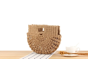 Detail of a semi-circular woven handbag with hollow knit texture and sturdy handle