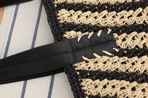 Close-up of contrast stripe straw beach bag showing woven texture and leather strap