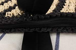 Macro shot of the sturdy black zipper and texture on this striped woven beach tote bag