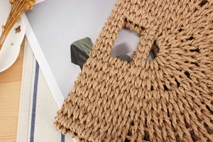 Close-up of handmade woven straw bag handle with dense texture and rustic craft details