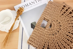 Detail of round straw handbag on a cafe table with coffee and dried flowers