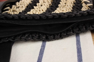 Macro shot of striped woven beach bag showing high-quality black zipper and texture