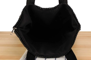 Top view of large black woven beach bag with secure zipper closure and spacious interior