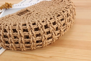 Close-up of the handcrafted hollow woven pattern and straw material texture on this bag
