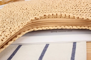 Detailed macro view of woven straw bag showing secure zipper closure and natural texture