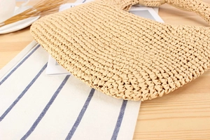 Detailed macro view of beige woven straw handbag with intricate natural wavy texture