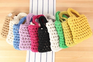 Close-up showing various colors of handmade crochet cotton rope tote bags with mesh texture