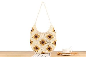 Detail of hand-woven cotton sunflower bag with floral crochet pattern and ivory strap