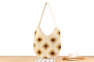 Detail of hand-woven cotton shoulder bag featuring vibrant sunflower floral patterns