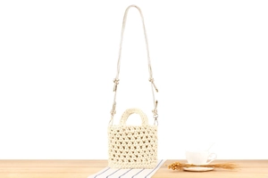 Detailed macro of handmade hollow-out woven cotton rope bag with round handles