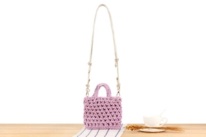 Detail showing the lavender handmade crochet mini bag with hollow woven cotton rope patterns