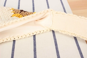 Close-up of handmade crochet bag showing sunflower pattern, inner lining and wide strap