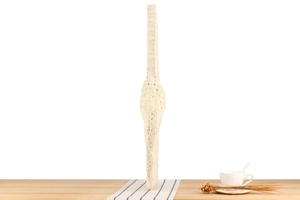 Dettaglio della borsa in cotone beige intrecciata a mano con motivi traforati