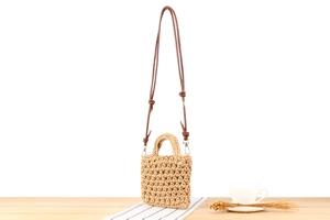 Detail of hollow hand-woven cotton rope bag with adjustable brown faux leather shoulder strap