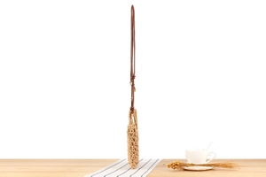 Detailed view of handmade woven cotton bag texture with brown leather shoulder strap