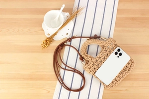 Detail of handmade cotton rope woven crossbody bag with hollow crochet texture and leather strap