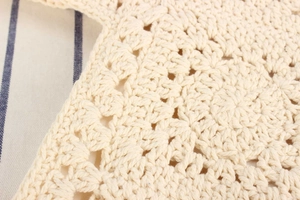 Dettaglio ravvicinato della borsa in cotone intrecciato a mano color crema con ricami