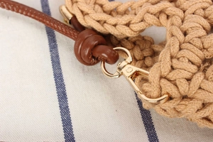 Close-up of handmade cotton woven bag with brown leather strap and gold lobster clasp
